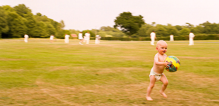 Toddler running with ball on cricket field, Sussex, England - Getty ref: 3413-000013 - direct link 
  on contact page